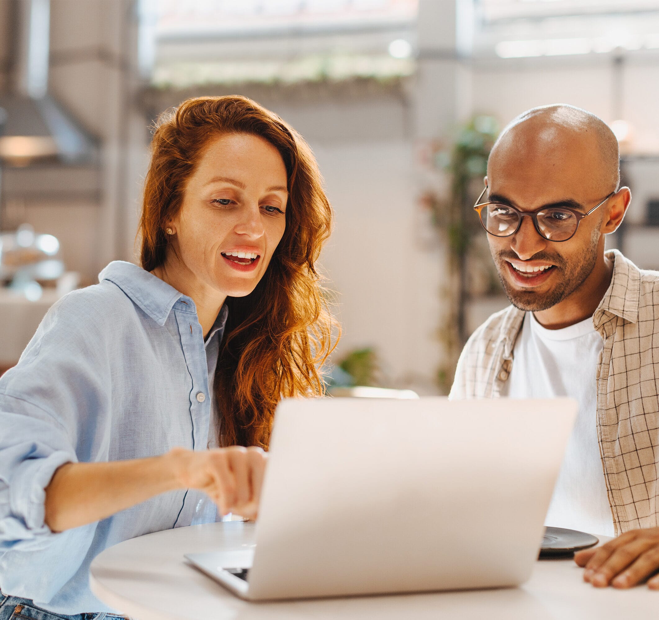 A ginger white female pointing at her laptop and discussing HR Support