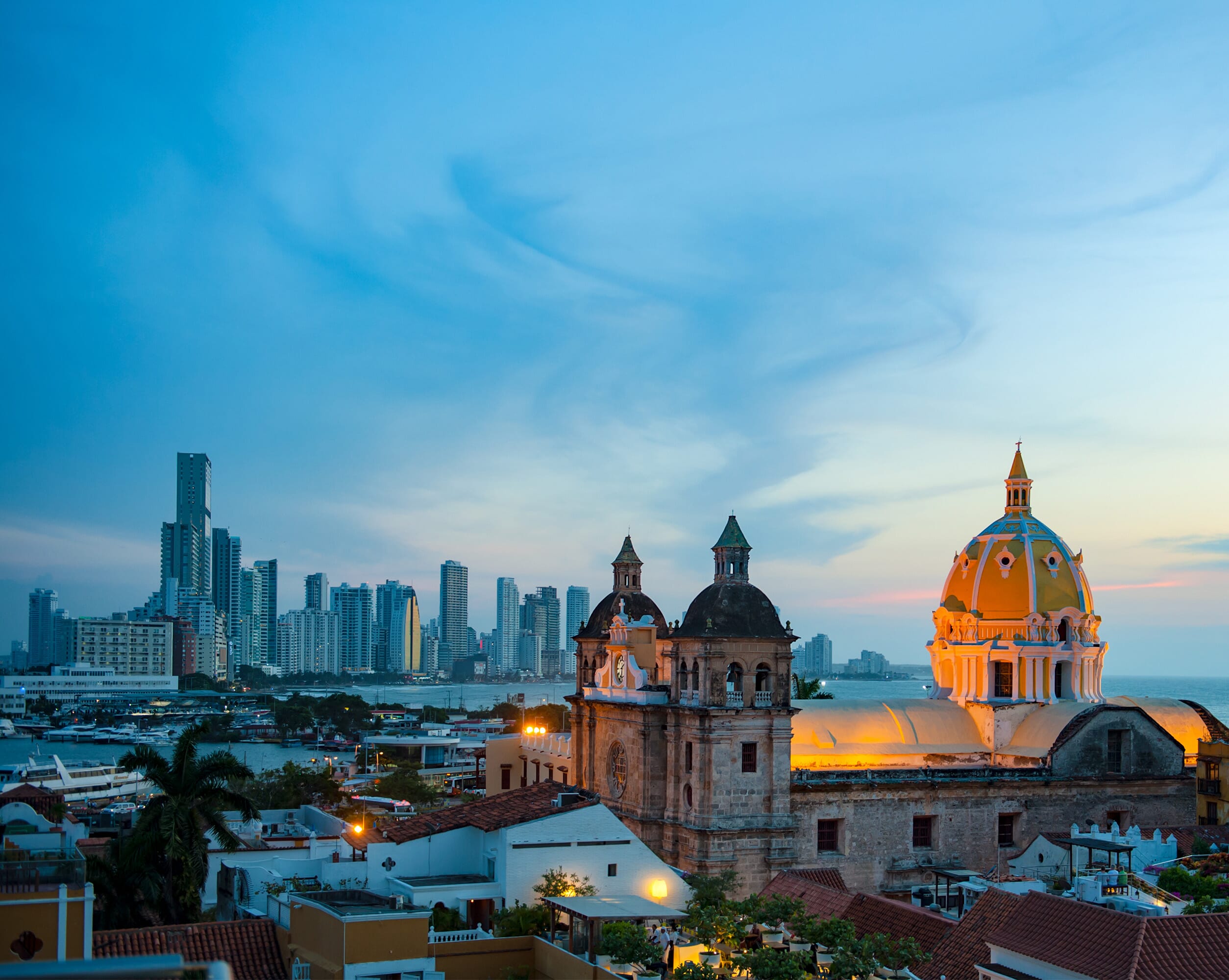 The Americas present a wide spectrum of growth opportunities across both established and emerging markets. With regional expertise and cross-border capabilities, we deliver customised outsourcing solutions that optimise operations, increase efficiency, and support long-term success throughout North, Central, and South America. This image is of the city scape of Colombia with the sunset.